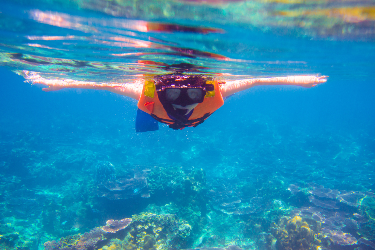 girl with mask snorkeling in clear water